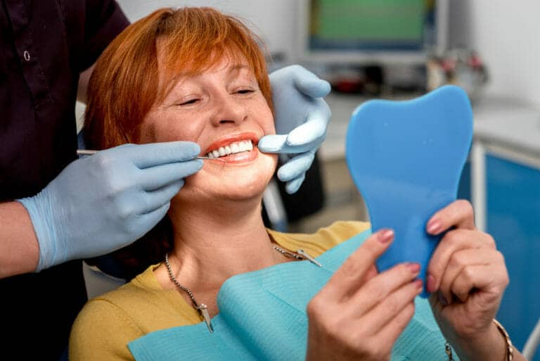 Patiente avec des nouvelles prothèses. Avancée sociale. chez le denturiste ou le dentiste